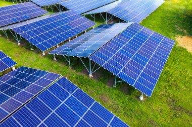 Temiz ekolojik elektrik enerjisi üretmek için sıra sıra güneş fotovoltaik panelleri olan sürdürülebilir büyük elektrik santralinin havadan görünüşü. Sıfır emisyon kavramı ile yenilenebilir elektrik.