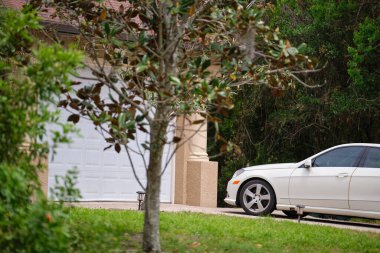 Geniş garajın önüne park edilmiş bir araba. Yeni modern Amerikan evinin beton yolu üzerinde çift kapı..