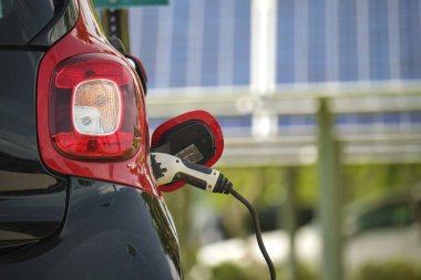 Şehrin caddesinde park halindeki güneş enerjisi yenilenebilir enerji kaynağından elektrik yüklü bir elektrik prizi..