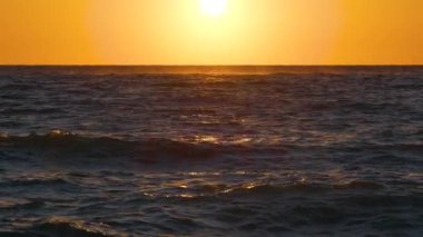 Ocean sunset. Big white sun on dramatic bright sky background, soft evening horizont over sea dark water.