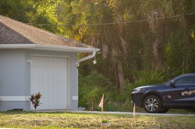 Geniş garajın önüne park edilmiş bir araç. Tipik modern Amerikan evinin kaldırımlı yolunda çift kapı..