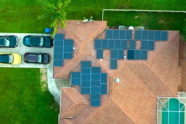 Ordinary residential house in USA with rooftop covered with solar photovoltaic panels for producing of clean ecological electrical energy in suburban rural area. Concept of autonomous home.