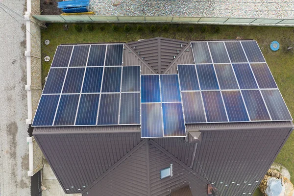 Residential house with rooftop covered with solar photovoltaic panels for producing of clean ecological electrical energy in suburban rural area. Concept of autonomous home.