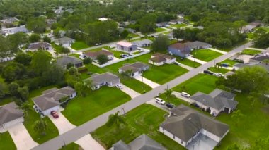 Florida 'nın sakin yerleşim bölgesinde yeşil palmiye ağaçları arasında özel evleri olan küçük bir Amerikan banliyö manzarası..