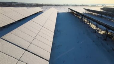 Kar, temiz elektrik enerjisi üretmek için birçok sıra güneş fotovoltaik paneliyle sürdürülebilir elektrik santralini kapladı. Kışın yenilenebilir elektriğin düşük etkisi.