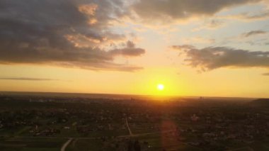 Köy evlerinin ve uzak yeşil tarlaların hava manzarası. Parlak yaz akşamlarında ekinlerin büyüdüğü tarlalar..