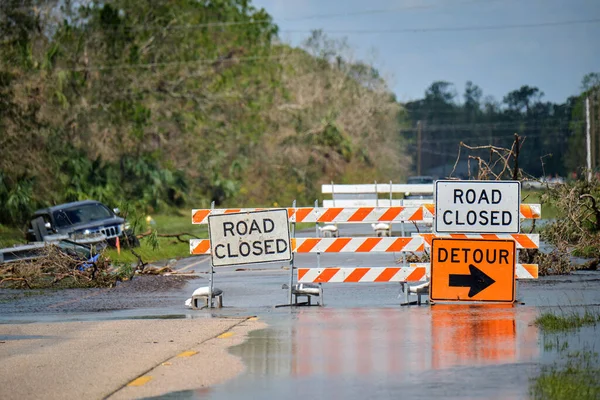 Hurricane Ian flooded street with road closed signs blocking driving of cars. Safety of transportation during natural disaster concept.