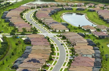 Florida 'daki kapalı yaşam kulübünde böcek koruması için metal çerçeveli sivrisinek ağıyla kaplı havuzları olan pahalı modern evlerin havadan görünüşü..