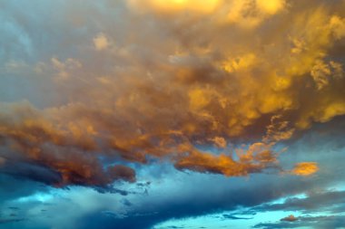 White fluffy cumulonimbus clouds forming before thunderstorm on evening sky. Changing stormy cloudscape weather at sunset.