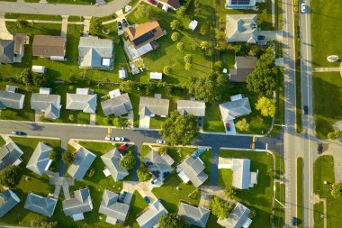 Aerial view of small town America suburban landscape with private homes between green palm trees in Florida quiet residential area. clipart
