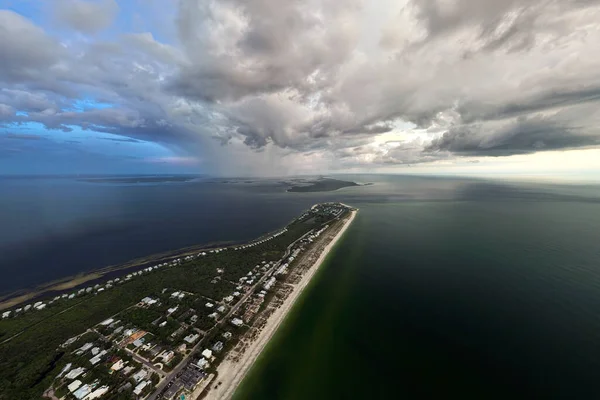 View from above of large storm approaching over residential houses in island small town Boca Grande on Gasparilla Island in southwest Florida. Climate change concept.