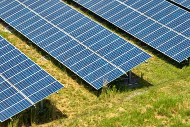 Temiz elektrik enerjisi üretmek için birçok sıra güneş fotovoltaik paneli bulunan sürdürülebilir büyük elektrik santralinin havadan görünüşü. Sıfır emisyon kavramı ile yenilenebilir elektrik.