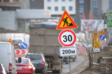 Yol çalışmaları trafik işaretlerini uyardı. Şehir caddesinde inşaat çalışması ve yavaş hareket eden arabalar..