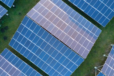 Temiz ekolojik elektrik enerjisi üretmek için sıra sıra güneş fotovoltaik panelleri olan sürdürülebilir büyük elektrik santralinin havadan görünüşü. Sıfır emisyon kavramı ile yenilenebilir elektrik