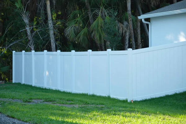 White plastic fence for back yard protection and privacy.