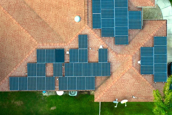 Standard american residential house with rooftop covered with solar photovoltaic panels for producing of clean ecological electrical energy in suburban rural area. Concept of autonomous home.