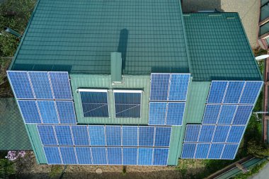 Şehrin kırsal kesimlerinde temiz ekolojik elektrik enerjisi üretmek için güneş fotovoltaik panellerle kaplı özel bir çatı. Özerk ev kavramı.