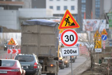 Yol çalışmaları trafik işaretlerini uyardı. Şehir caddesinde inşaat çalışması ve yavaş hareket eden arabalar..