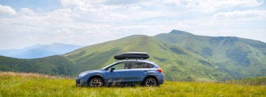 Blue off road car on mountain trail. Traveling by auto, adventure in wildlife, expedition or extreme travel on SUV automobile.