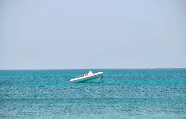 穏やかな波に浮かぶアンカーの上に白いスピードボートと青い海の水のリップルの表面と海の風景 — ストック写真