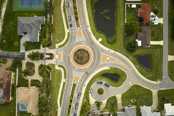 Aerial view of road roundabout intersection with moving cars traffic. Rural circular transportation crossroads.