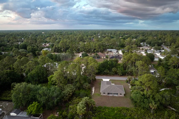 Aerial view of small town America suburban landscape with private homes between green palm trees in Florida quiet residential area.