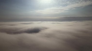 Dünya 'nın yüksek irtifasında, yağmur fırtınasından önce oluşan kabarık kümülüs bulutlarıyla kaplı uçak penceresinden hava görüntüsü.