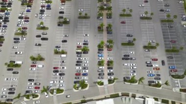 Otoparkta park yerleri ve yönler için çizgiler ve işaretlerle park edilmiş birçok renkli arabanın hava manzarası..