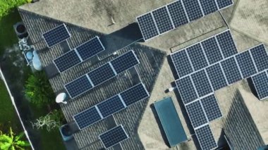 Temiz ekolojik elektrik enerjisi üretmek için mavi güneş fotovoltaik panelleri olan normal Amerikan ev çatısı. Sıfır emisyon kavramı ile yenilenebilir elektrik.