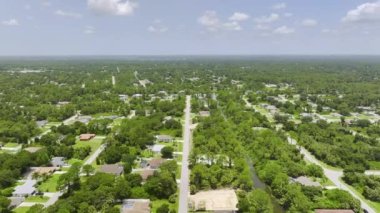 Florida 'nın sakin yerleşim bölgesinde yeşil palmiye ağaçları arasında özel evleri olan küçük bir Amerikan banliyö manzarası..