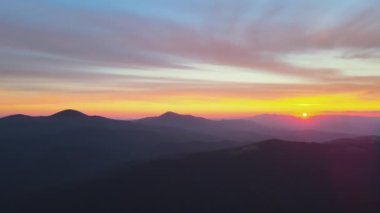 Gün batımında puslu tepeleri ve sisli vadisi olan güzel dağ panoramik manzarası.