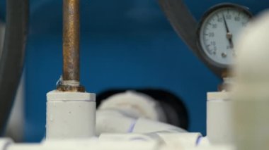 Amerikan evindeki su filtreleme sisteminin arızalı bağlantısından sızan plastik borular..