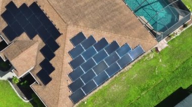 Kenar mahallelerde temiz ekolojik elektrik enerjisi üretmek için çatısı güneş fotovoltaik panellerle kaplı standart bir Amerikan yerleşim evi. Özerk konut kavramı.