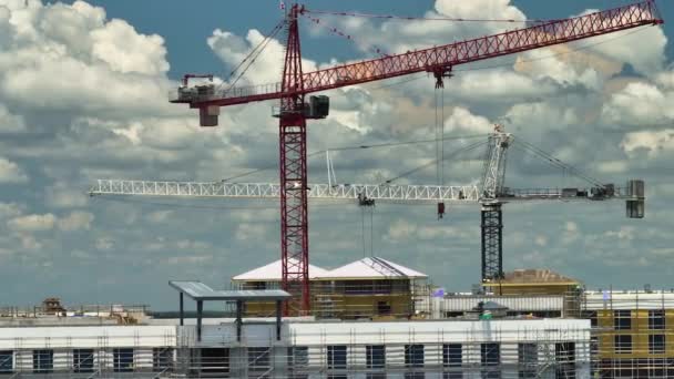 高層住宅のアパートの建物の建設現場でのタワーリフティングクレーンの空中ビュー 不動産開発 — ストック動画
