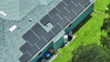 Aerial view of typical american building roof with rows of blue solar photovoltaic panels for producing clean ecological electric energy. Renewable electricity with zero emission concept.