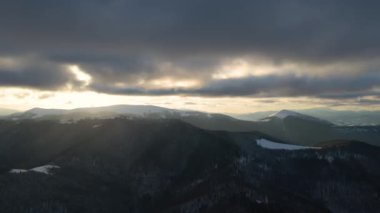 Gün batımında soğuk dağlarda karlı ağaçlarla kaplı kış manzarası..
