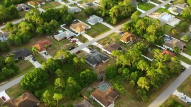 Florida 'nın sakin kırsal kesimindeki yeşil palmiye ağaçları arasındaki banliyö özel evlerinin hava manzarası.