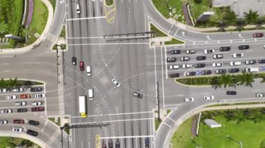 Trafik ışıkları, hareket halindeki arabalar ve kamyonlarla büyük çoklu yol kesişiminin havadan görüntüsü.