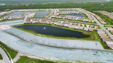 Florida 'nın kapalı banliyö bölgesinde inşaat halindeki aile evleri ile birlikte gayrimenkul gelişiminin havadan görüntüsü. Büyüyen Amerikan banliyöleri kavramı.