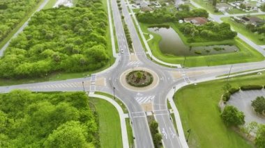 Aerial view of road roundabout intersection with moving cars traffic. Rural circular transportation crossroads.