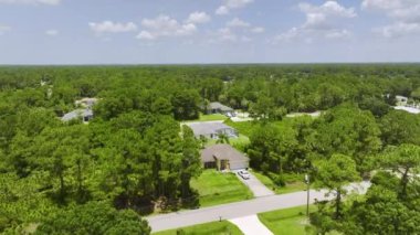 Florida 'nın sakin yerleşim bölgesinde yeşil palmiye ağaçları arasında özel evleri olan küçük bir Amerikan banliyö manzarası..