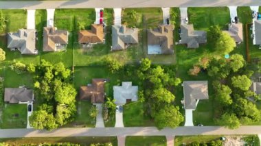 Florida 'nın sakin yerleşim bölgesinde yeşil palmiye ağaçları arasında özel evleri olan küçük bir Amerikan banliyö manzarası..