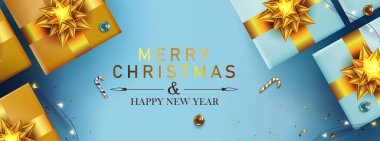 Mavi Noel kartı, içinde altın rengi fiyonk, yanan çelenk, altın süslemeler olan hediye kutuları..
