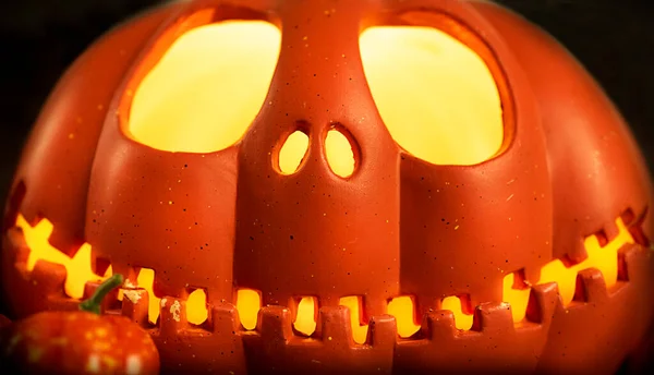 Pompoenkop Jack-o-lantaarn close-up met gloeiende ogen en oranje herfstpompoenen, zeer donker stilleven, achtergrond voor Halloween — Stockfoto