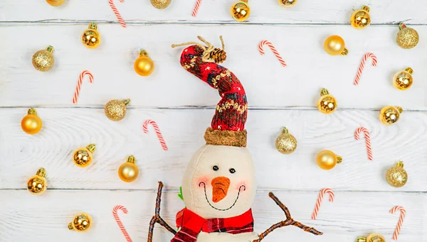 Christmas toy snowman on white wooden background with copy space, front view for postcards and gift bags