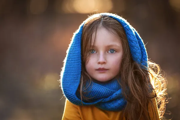 Retrato de una hermosa niña con ojos azules sobre un fondo marrón — Foto de Stock