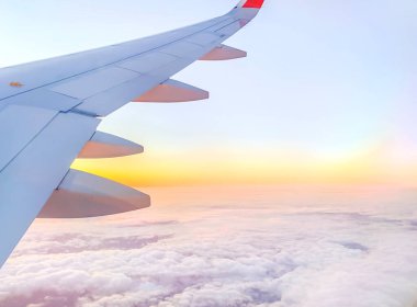 Gün batımında gökyüzünde uçak kanadı, kopyalanmış uzay ile gökyüzünde uçak uçuşu.