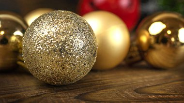 Ahşap arka planda altın noel topları, ışıklar ve kopyalama alanı.