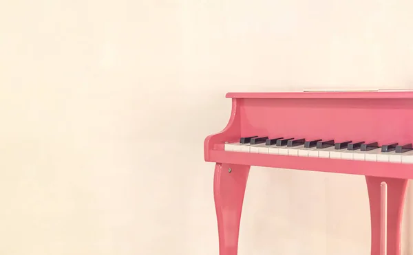 Pink baby piano near the wall close up front view with copy space — Stockfoto