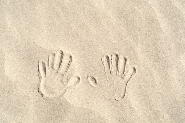 Rukopisy dlaní rukou na písku horní pohled z kopírovacího prostoru — Stock fotografie